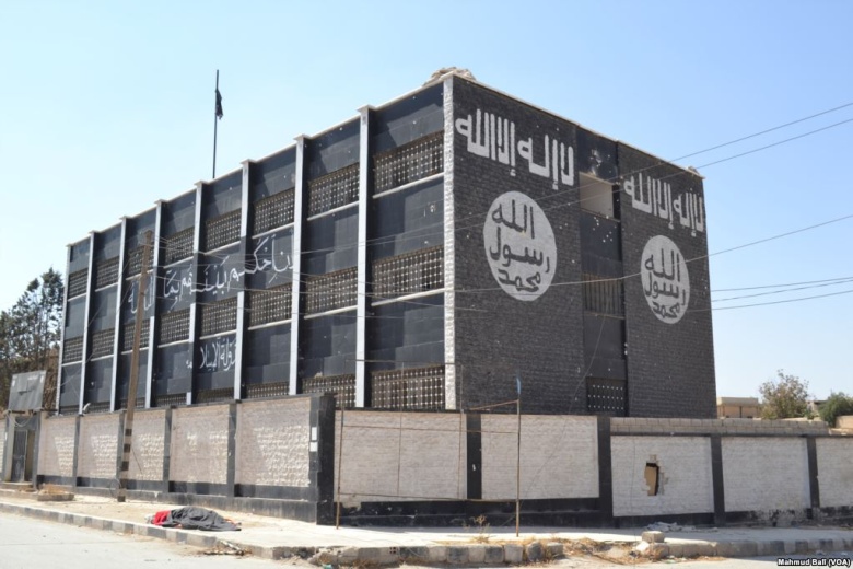 Административное здание в сирийском городе Манбидже с нанесённой символикой «ИГ», 2016 год