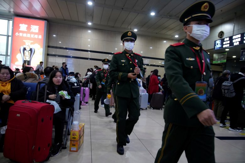 Офицеры внутренних войск в масках патрулируют вокзал, Шанхай. Фото: Aly Song / Reuters