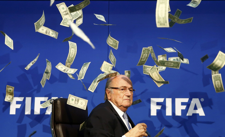 Британский комик Ли Нельсон в знак протеста против коррупции в футболе разбрасывает над президентом FIFA Зеппом Блаттером поддельные долларовые банкноты.