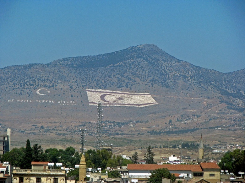 «Как счастлив тот, кто называет себя турком»: афоризм Ататюрка рядом с флагом ТРСК на горе близ горда Кирении (Гирены)