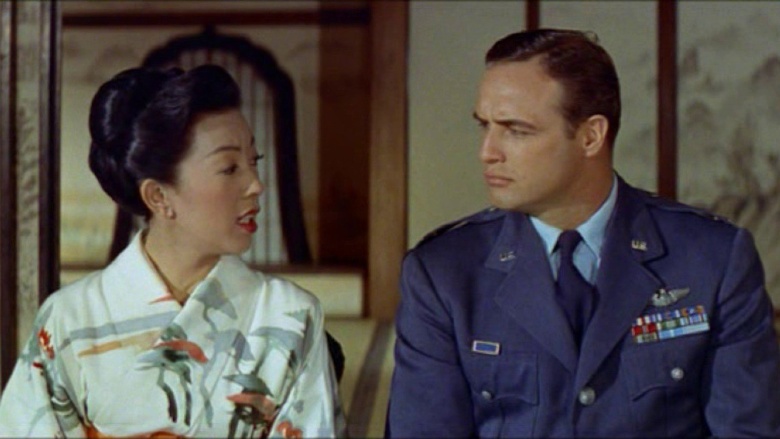 Кадр из фильма Джошуа Логана “Сайонара” (1957). Главный герой, американский герой-пилот в исполнении Марлона Брандо (справа) влюбляется в японскую актрису (Миёси Умеки). Роман “победителя” и “побежденной” резко осуждают и американское командование, и японское общество.