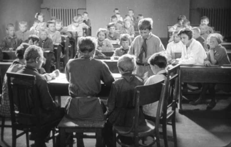 Пионерский суд. Учительница (в белой блузе, на передней парте справа) одобрительно наблюдает за ходом "процесса". Кадр из фильма  Константина Болотова «Вредитель», 1929