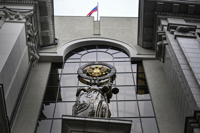 Статуя Фемиды, древнегреческой богини правосудия, и российский герб у входа в Верховный суд России. Москва, 17 апреля 2024 года