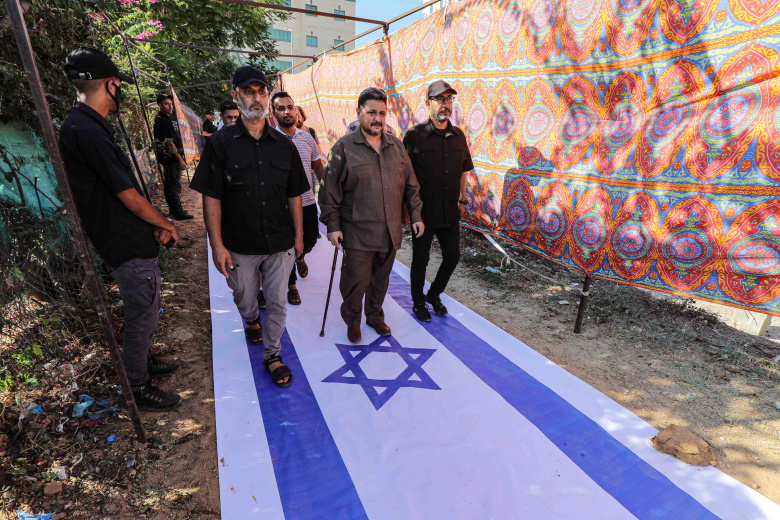 Сектор Газа, 6 октября 2023 года. Сторонники джихада проходят по израильскому флагу