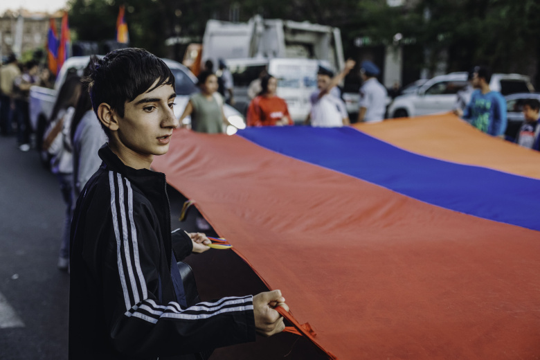Молодой человек несет флаг Армении во время шествия зажженных свечей в память о армянах, павших в последней нагорно-карабахской войне