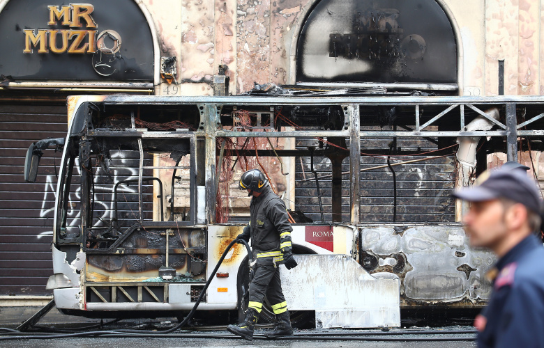 Пожарный у сгоревшего автобуса в Риме