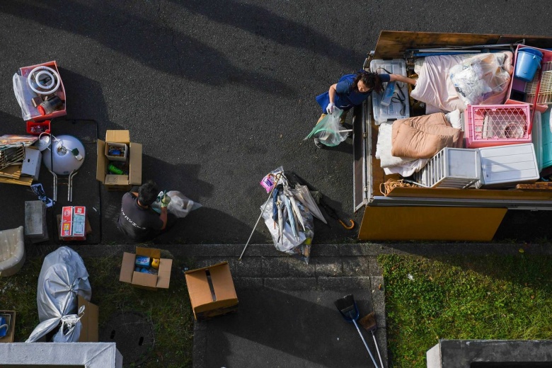 Работники компании Tail Project во время уборки вещей. Фото: Noriko Hayashi / Bloomberg