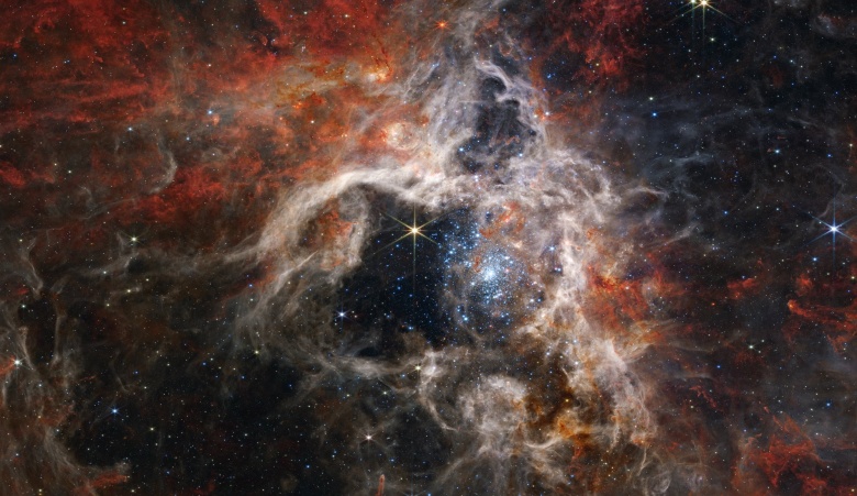 Область формирования звезд в туманности Тарантул, находящейся на расстоянии ок. 161 000 световых лет от Солнечной системы. Изображение получено космическим телескопом James Webb в сентябре 2022 года.