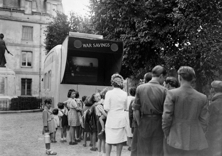 Люди смотрят фильм в передвижном кинотеатре в рамках кампании «Военные сбережения»? Лондон, Великобритания. Кампания «Военные сбережения» была организована в ноябре 1939 года для поддержки армии..
