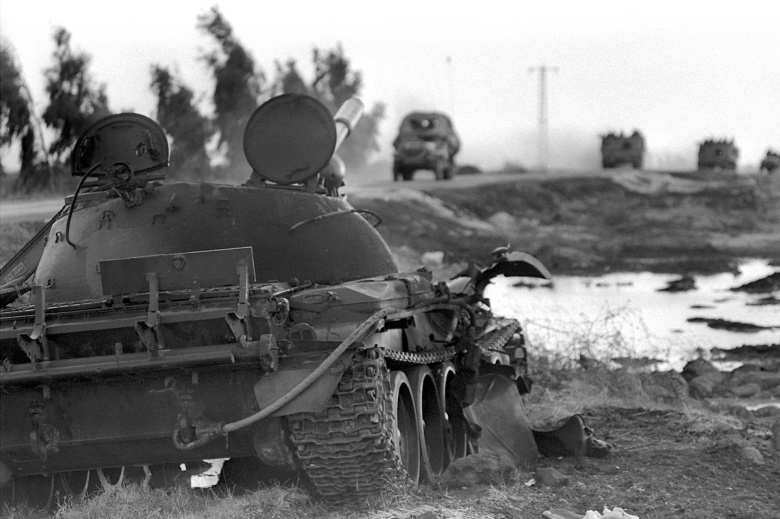 Израильская колонна движется на север мимо подбитого сирийского танка на Голанских высотах во время войны Судного дня, 8 октября 1973 года