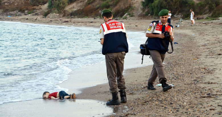 Сотрудники турецкой полиции с телом мальчика, утонувшего при попытке попасть на греческий остров Кос.