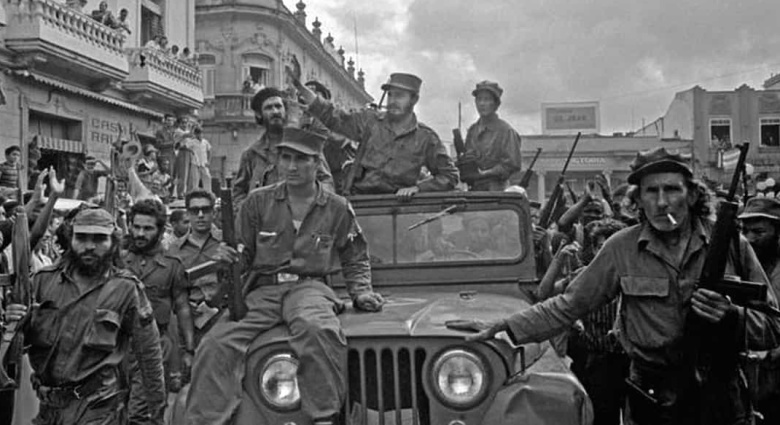 Фидель Кастро (стоит в автомобиле, в центре) в окружении охраны в 1959 году. ЦРУ планировало дискредитировать лидера коммунистической Кубы, распылив ЛСД в радиостудии, откуда Кастро произносил свои многочасовые речи в прямом эфире