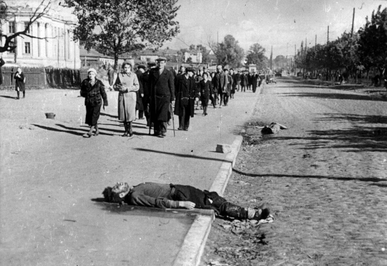 Киевских евреев конвоируют в Бабий Яр. На тротуаре и мостовой — тела участников предыдущих этапов, убитых при малейшем намеке на неповиновение или при попытке к бегству. Сентябрь-октябрь  1941