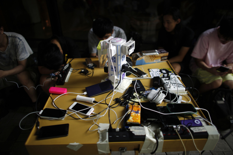 Протестующие в Гонконге заряжают телефоны. Фото: Carlos Barria / Reuters