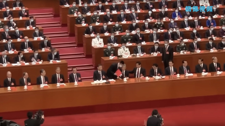 XX съезд Коммунистической партии Китая, 22 октября 2022 года. Бывшего китайского лидера Ху Цзиньтао поднимают с кресла и помогают покинуть зал заседаний (кадр из видео)
