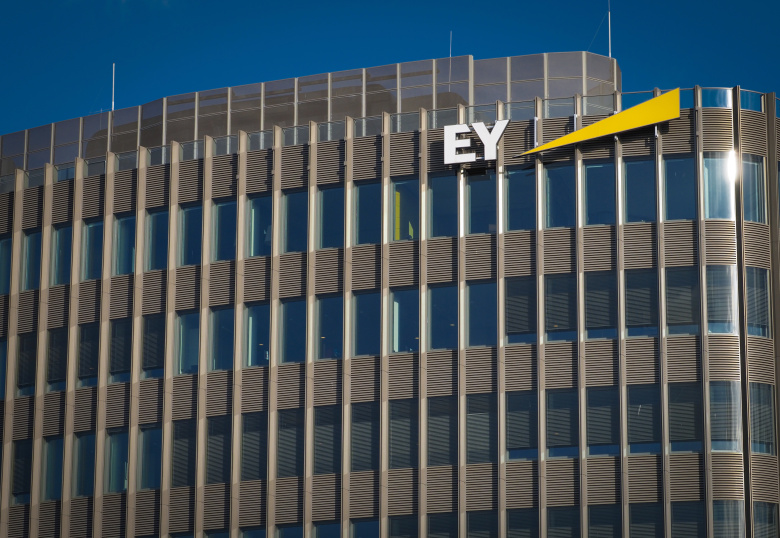 Логотип аудиторско-консалтинговой фирмы Ernst & Young (EY) на верхнем этаже высотного здания в районе Шпреедрайек на Фридрихштрассе, Берлин