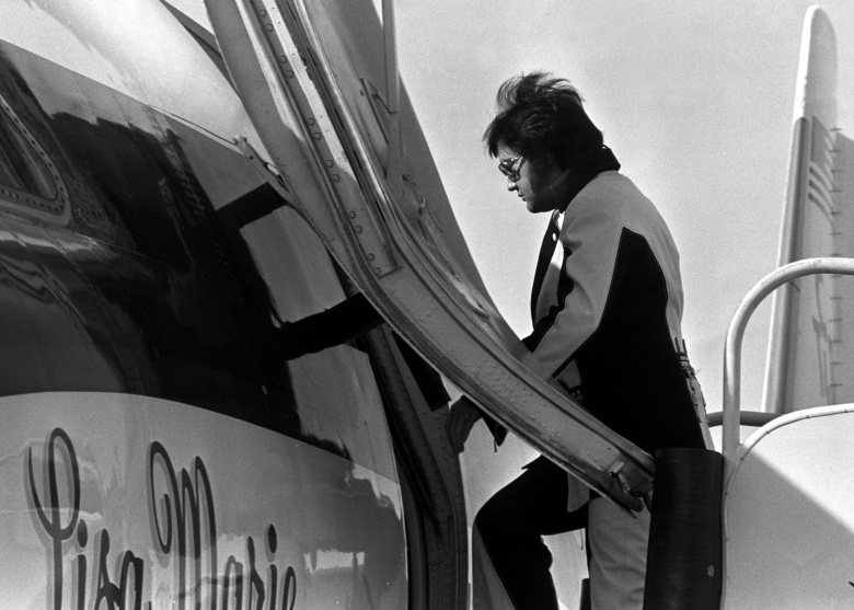Элвис Пресли садится в свой частный самолет The Lisa Marie после концертного выступления в Цинциннати, штат Огайо, США, 1 марта 1976 года