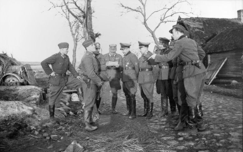 Бронислав Каминский (в самом центре — в профиль, смотрит на карту), вместе со своими подручными и немецкими полицейскими при планировании антипартизанской операции. Беларусь, 21 марта 1944 года
