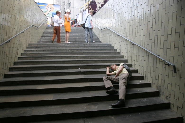 Пьяный мужчина на лестнице в переходе.