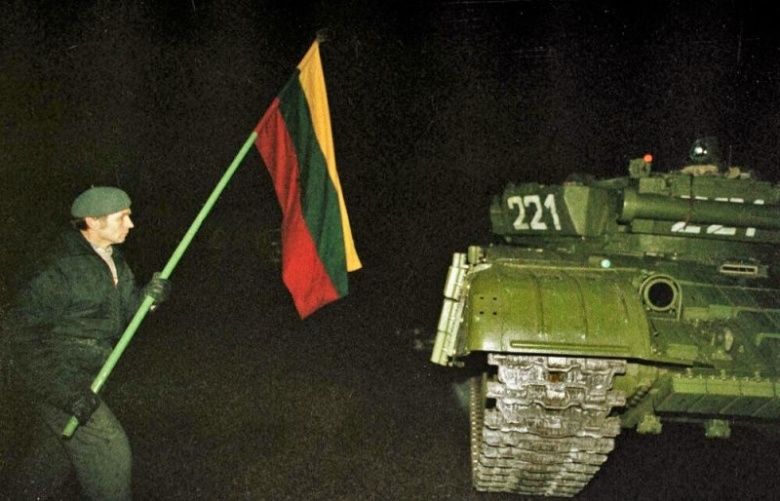 Один из протестующих с флагом около советского танка. Вильнюс, ночь 13 января 1991 года. Фото: wikipedia.org