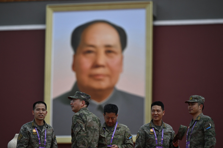 Китайские военнослужащие стоят перед портретом покойного лидера коммунистической партии Мао Цзэдуна