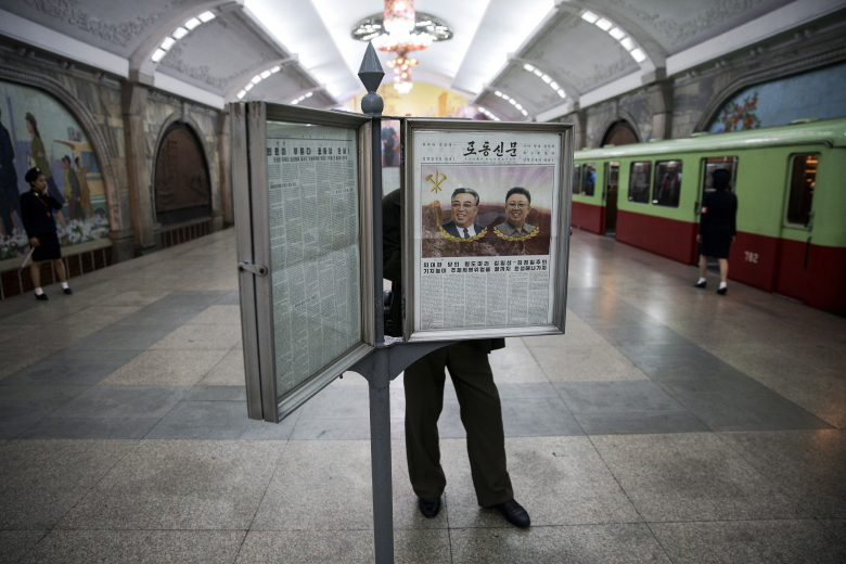 Мужчина читает газету в метро. Пхеньян.
