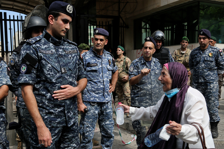 Протестующая вкладчица банка кричит на полицейского перед зданием ЦБ Ливана в Бейруте