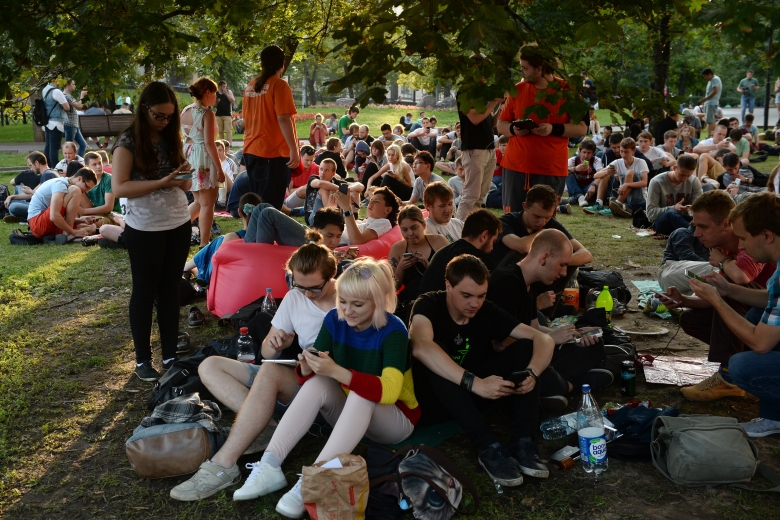 Молодые люди играют в Pokemon Go (Nintendo) в Ильинском сквере в Москве.