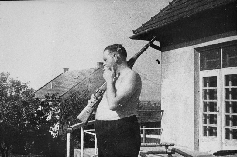Комендант концлагеря Плашов Амон Гёт выбирает жертву с балкона своей виллы над лагерем