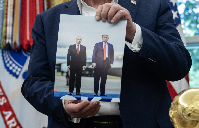 Фотография со встречи Дональда Трампа с Владимиром Путиным в руках у Дональда Трампа