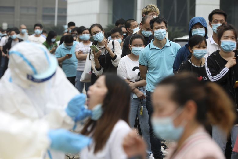 Взятие биоматериала для диагностики COVID-19 на фабрике в китайском Ухане после решения властей протестировать всех жителей города из-за новых случаев заражения коронавирусом. Фото: Chinatopix / AP / TASS