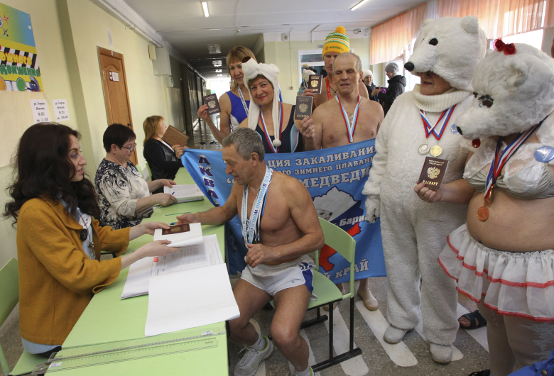 Члены клуба зимнего плавания "Полярный медведь" (Барнаул) голосуют на выборах президента России, 2018 год. Фото: Андрей Каспришин / Reuters