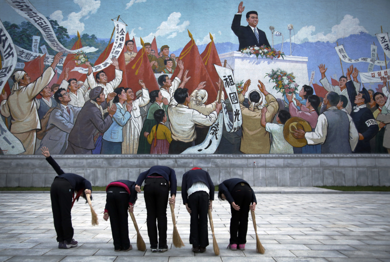 Школьницы кланяются портрету Ким Ир Сена. Пхеньян.