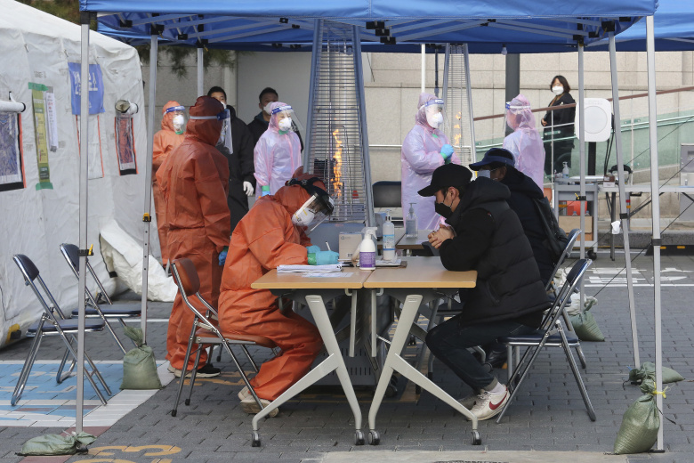 Медицинские работники тестируют предполагаемых заболевших коронавирусом в передвижном центре в Сеуле. Фото: Ahn Young-joon / AP / ТАСС