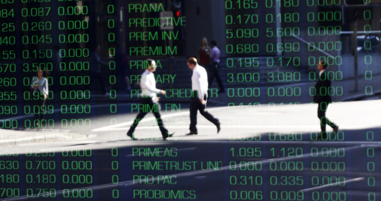 Люди отражаются в стекле с котировками.