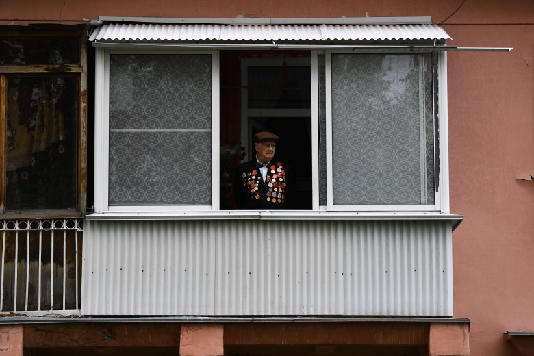 Ветеран ВОв Александр Примак на балконе своего дома во время поздравления с наступающим днем Победы. Новосибирск. Фото: Александр Кряжев / РИА Новости