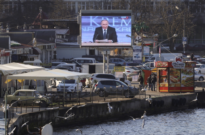 Пресс-конференция Владимира Путина, транслируемая в Севастополе. Фото: Pavel Rebrov  / Reuters