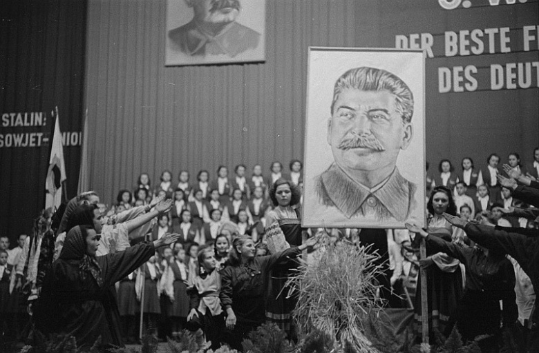 Восточнонемецкие школьники салютуют портрету Сталина. Лейпциг, 1950 год. После ХХ съезда КПСС в ГДР, как и в Советском Союзе, с неохотой приступили к демонтажу культа личности политика