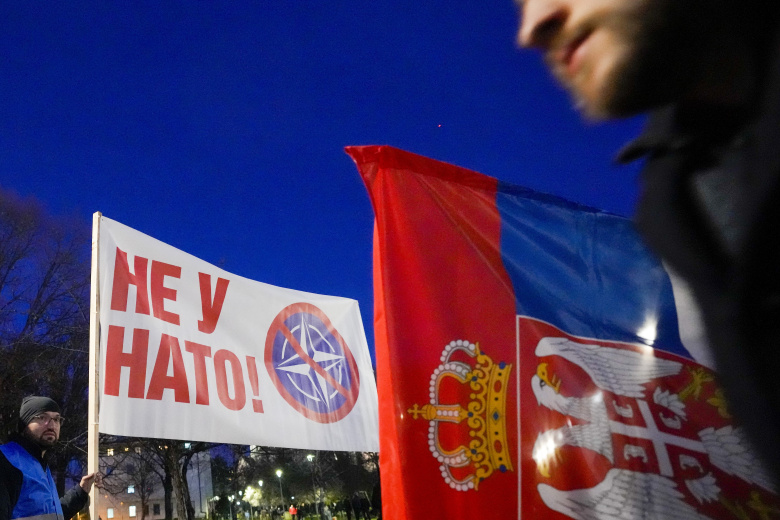 Демонстранты держат сербский флаг и транспарант с надписью: «Нет в НАТО!» во время акции протеста против сербских властей и франко-германского плана урегулирования Косово. Белград, 17 марта 2023 года