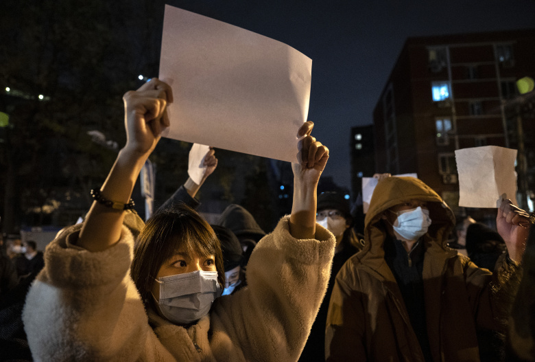 Пекин, 27 ноября 2022 года: протестующие против жестких ковидных ограничений держат в руках белые листы бумаги