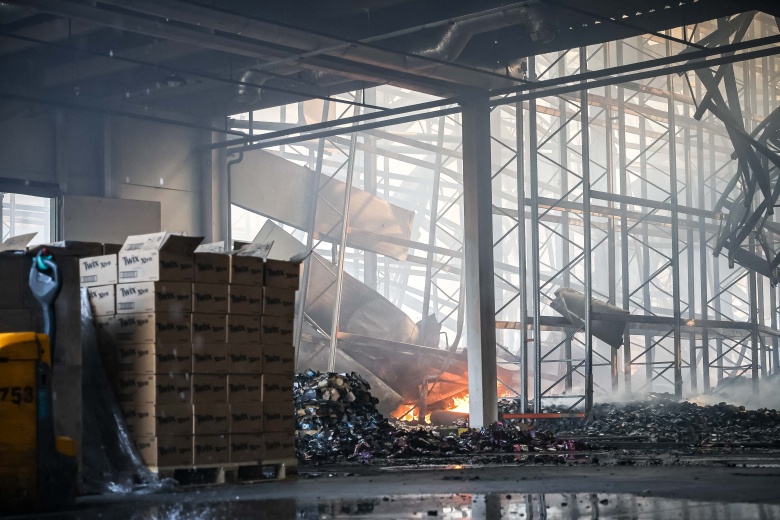 Вид на горящее предприятие, пожарные продолжают тушить возгорание после массированного обстрела со стороны российских военных