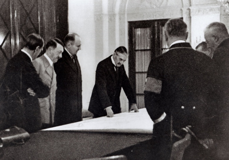 Участники Мюнхенской конференции, включая Адольфа Гитлера, над картой Европы