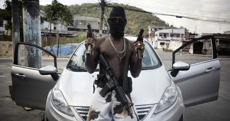 Член банды по кличке Траффиканте позирует с оружием в фавеле недалеко от Рио-де-Жанейро