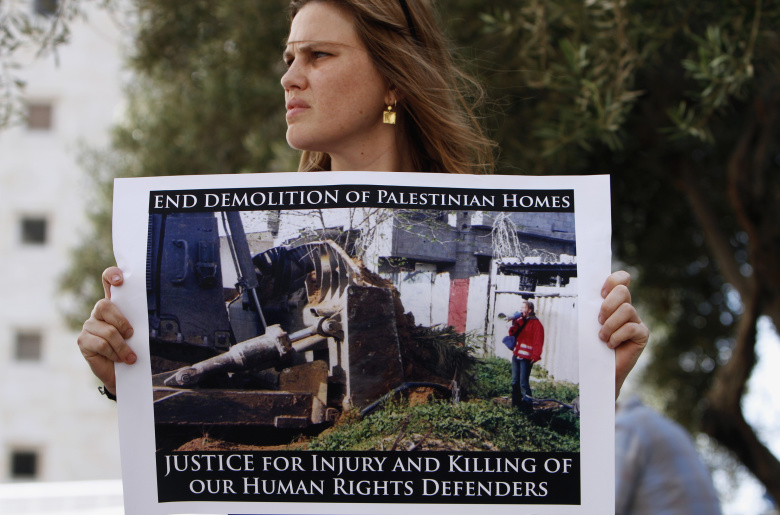 Активистска держит плакат, на котором изображена Рэйчел Корри, за пределами Хайфского районного суда, Израиль. Фото: Amir Cohen / Reuters