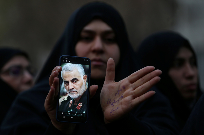 Иранская женщина держит телефон с портретом убитого Касема Сулеймани. Фото: Nazanin Tabatabaee / WANA / Reuters
