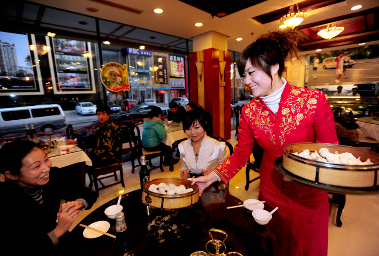 Официантка подает клиентам пельмени в ресторане в Шэньяне, провинция Ляонин, Китай