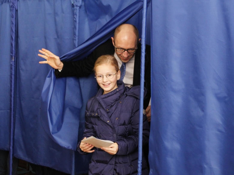 Премьер-министр Украины Арсений Яценюк с дочерью во время голосования. Фото: REUTERS / Valentyn Ogirenko