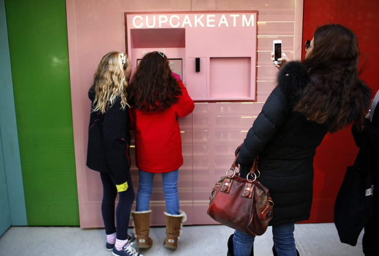 Девочки делают покупки в автомате Cupcake.