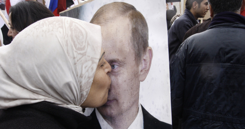 Сирийская женщина целует фото президента РФ Владимира Путина на митинге напротив посольства РФ в Дамаске. 2012 год.