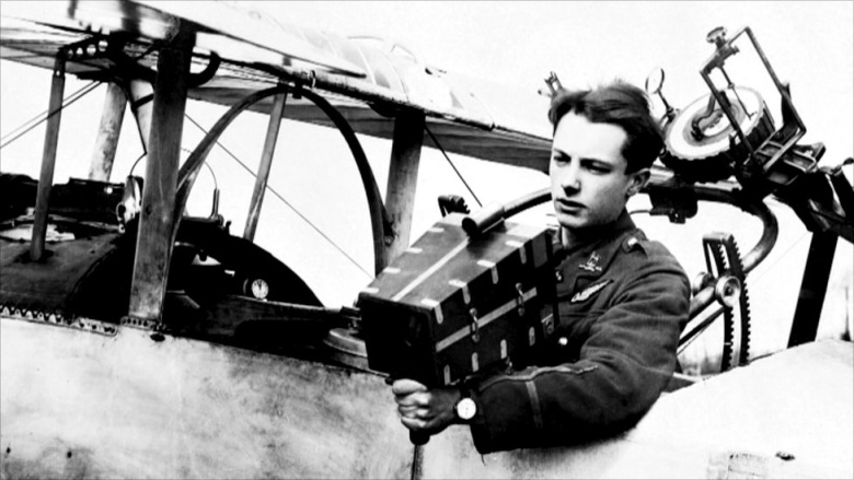 Британский аэрофотосъемщик с ручной камерой на заднем сиденье аэроплана Nieuport